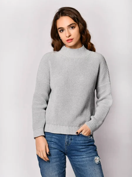 Młoda kobieta piękny pozowanie w nowy dorywczo szara bluzka sweter — Zdjęcie stockowe