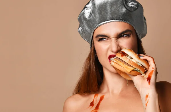 Vrouw houd Hamburger sandwich met ketchup met hongerige mond op lichte bruine achtergrond — Stockfoto