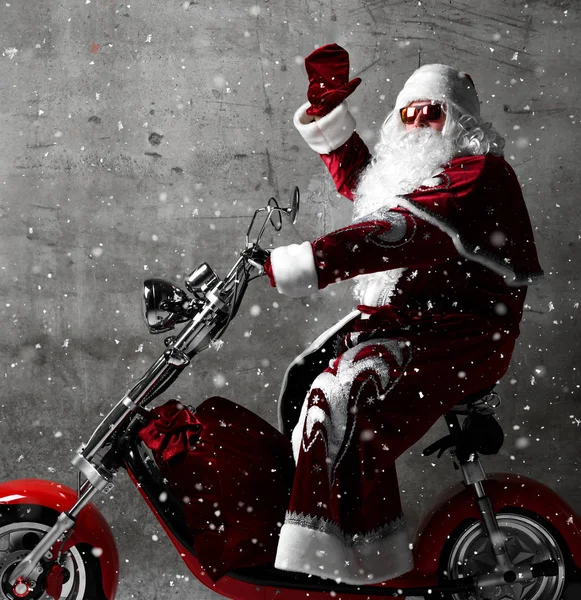 Santa Claus paseo moto eléctrica scooter con bolsa llena de regalos y espacio de copia de texto — Foto de Stock