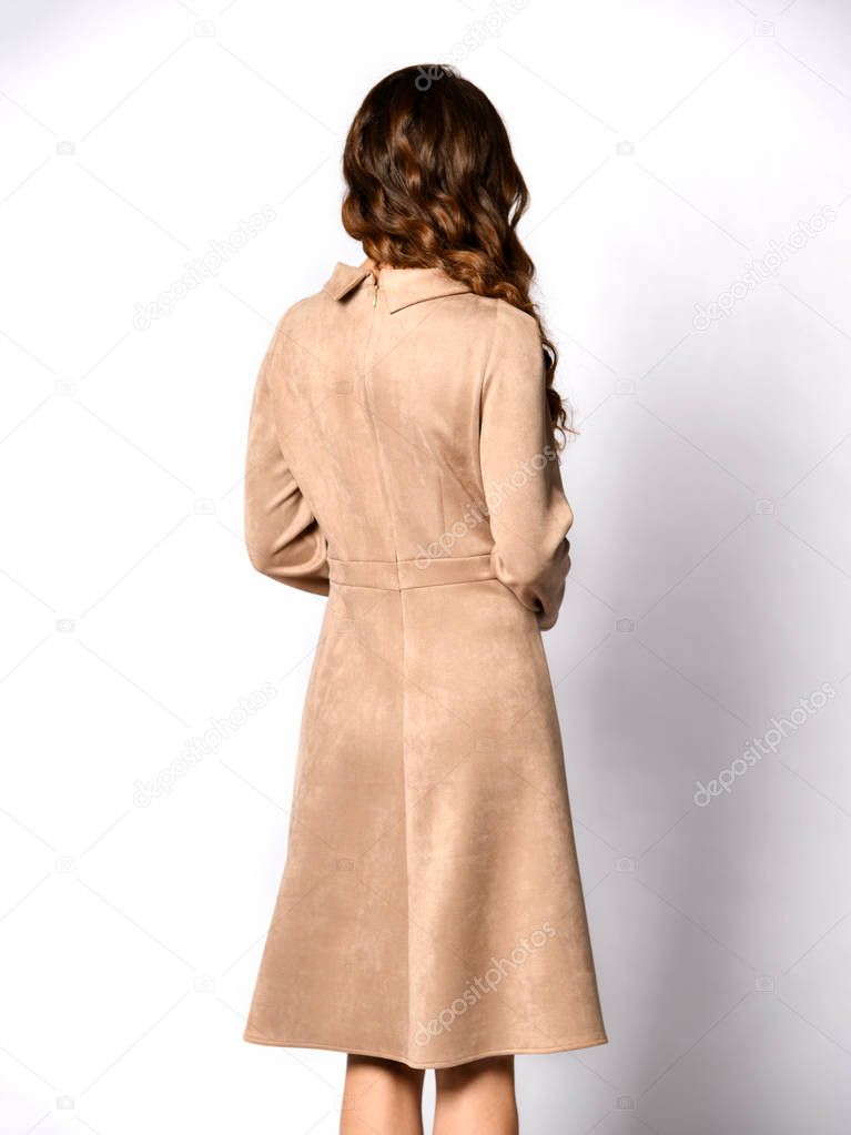 Young beautiful woman posing in new gray suede winter fashion dress 