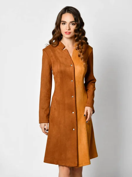 Young beautiful woman posing in new brown suede winter fashion dress