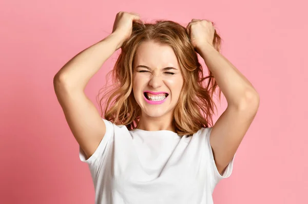 Mulher emocional gritando gritando gritando closeup retrato no fundo rosa puxando cabelo cabeça — Fotografia de Stock