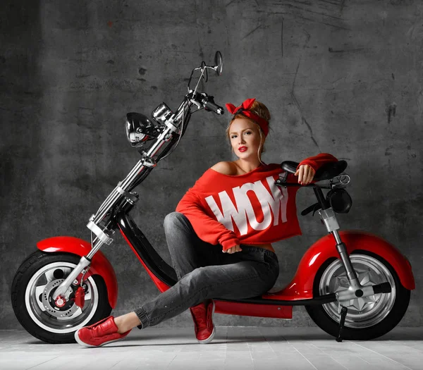 Donna seduta su moto scooter stile pinup retrò in camicetta rossa e jeans — Foto Stock