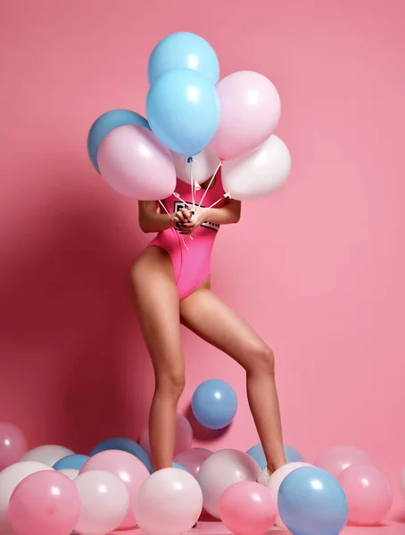 Mujer rubia alegre de moda en fiesta de cumpleaños ocultar la cara detrás de globos de aire de color pastel — Foto de Stock