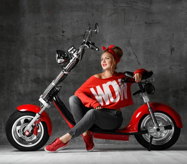 Donna seduta su moto scooter stile pinup retrò in camicetta rossa e jeans — Foto Stock