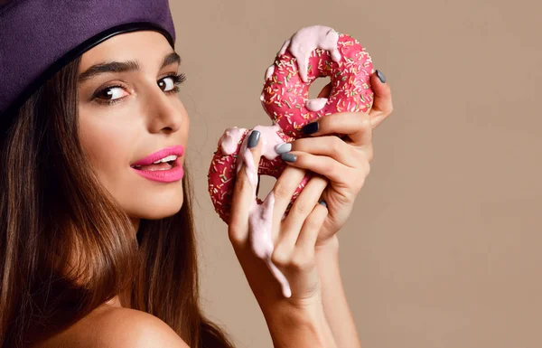 Mujer comer dulce rosado azúcar rosquillas hambriento boca en luz marrón fondo — Foto de Stock