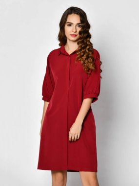 Genç güzel kadın yeni koyu kırmızı moda kış gerdanlık üzerinde beyaz bir elbiseyle poz 