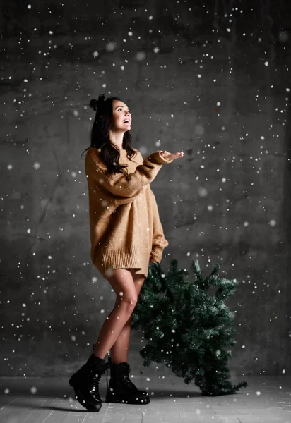 Hermosa mujer hipster con abeto de Navidad en suéter de punto sexy blusa bajo la nieve — Foto de Stock