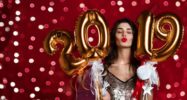 Vrouwen Nieuwjaar vieren feest gelukkig kussen met Kerstmis lights confetti en 2019 gouden ballonnen — Stockfoto