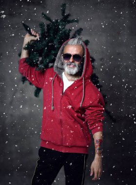 Şık modern Santa yaşlı adam kırmızı moda hoodie ve güneş gözlüğü Merry Christmas