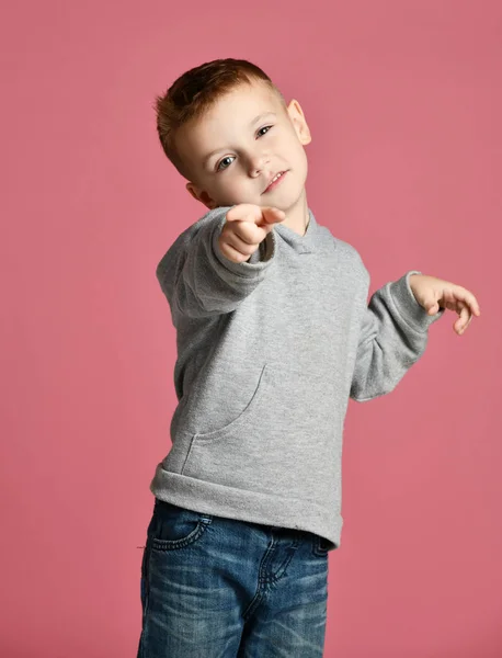 Jovem garoto de capuz cinza apontando um dedo na esquina sorrindo isolado no rosa — Fotografia de Stock