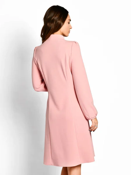Joven hermosa mujer posando en el nuevo vestido de invierno rosa vista trasera —  Fotos de Stock
