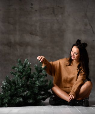 Güzel hipster kadın seksi örgü kazak bluz içinde oturan Noel köknar ağacı