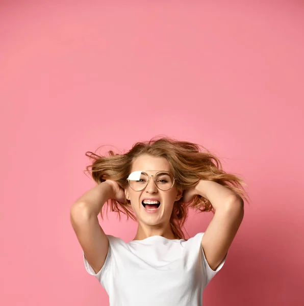 Mulher em t-shirt branca e óculos modernos posando gritando com as mãos para cima em rosa — Fotografia de Stock