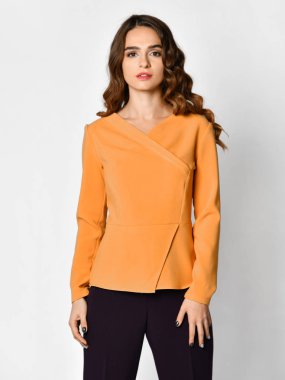 Genç güzel esmer kadın yeni rahat sarı turuncu bluz kazak ve siyah pantolon poz