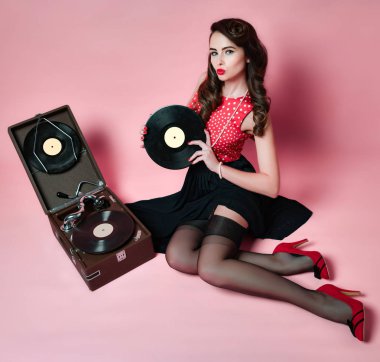 Göz alıcı pinup kız retro gramofon, pembe arka plan öpüşme Lp vinil kaydı tutan yakınındaki yalan