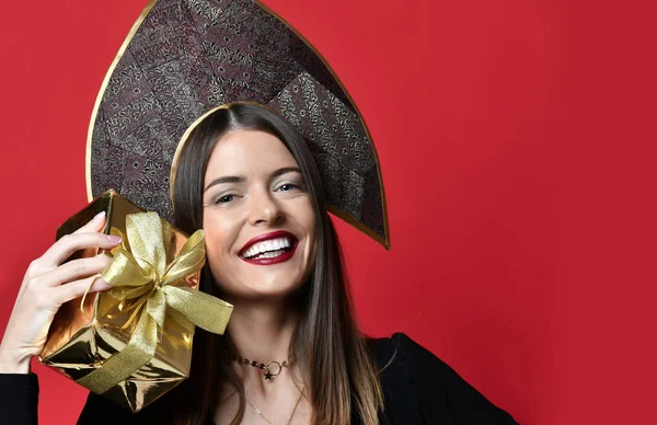 Mooie vrouw houden goud kerstcadeautjes giften voor nieuwe jaarviering in kokoshnik hoed — Stockfoto