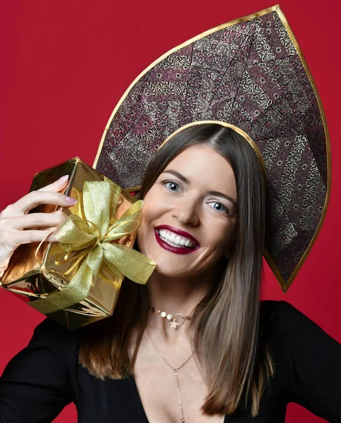 Mooie vrouw houden goud kerstcadeautjes giften voor nieuwe jaarviering in kokoshnik hoed — Stockfoto