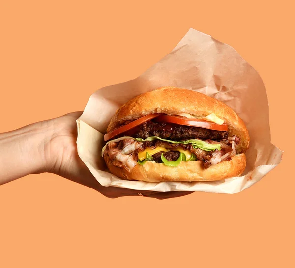 Kobieta ręce trzymać duże cheeseburger grilla kanapkę z marmuru wołowiny na fioletowy — Zdjęcie stockowe