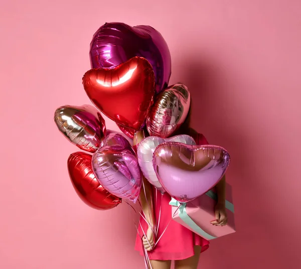 Menina com corações coloridos balões de ar escondidos atrás na festa de aniversário de férias se divertindo e celebrando com presente — Fotografia de Stock