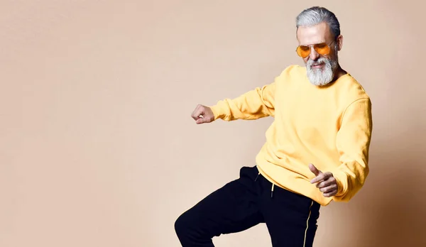 Щасливий старший мільйонер чоловік танцює в жовтих сонцезахисних окулярах стильні модні чоловіки старші — стокове фото