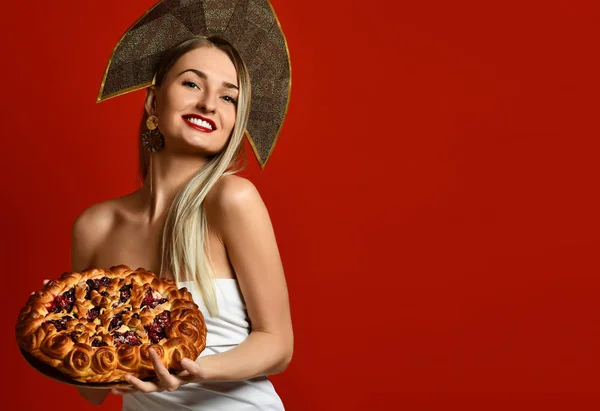 Donna in russo tradizionale cappello cappello kokoshnik felice sorridente tenere dolce ciliegia torta fatta in casa gustoso panino — Foto Stock