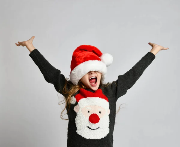 Natal Papai Noel ajudante em chapéu vermelho sorridente menina criança com as mãos para cima propagação — Fotografia de Stock