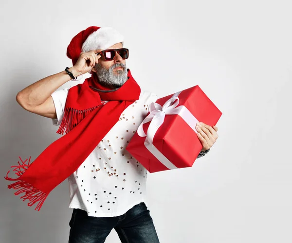 수석 수염된 남자 코너 보고 회색 배경 위에 빨간 선물 상자를 들고 — 스톡 사진