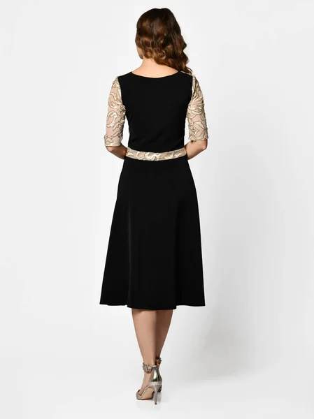 Молода красива жінка позує в новій темно-чорній моді зимова сукня заднього виду — стокове фото