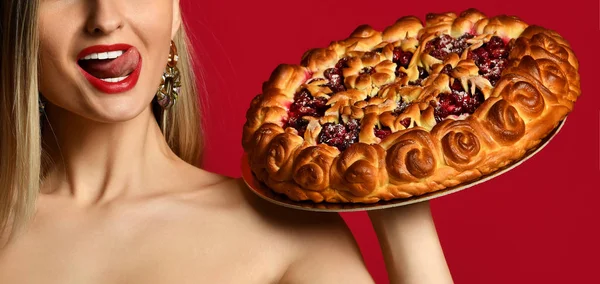 年轻的女人高兴举行甜樱桃自制馅饼美味的面包上红色 — 图库照片