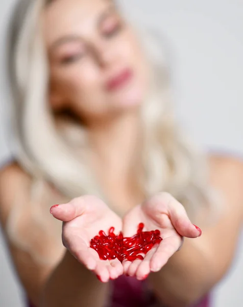 Femme tenir rouge capsules cosmétiques soin de la peau traitement sérum capillaire dans les mains — Photo