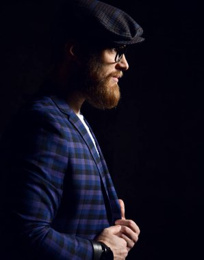 Sakal bıyık ve moda kap ve mavi kare ceket gözlük ile acımasız iş adamı 