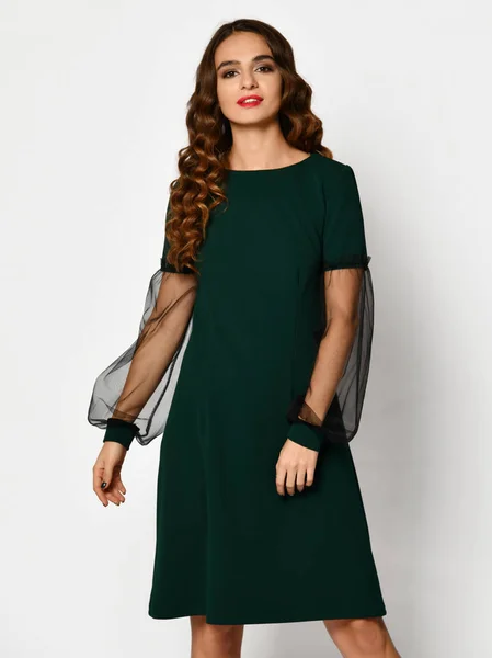Молодая красивая женщина позирует в новой темной зеленой моде зимнее платье на белом — стоковое фото