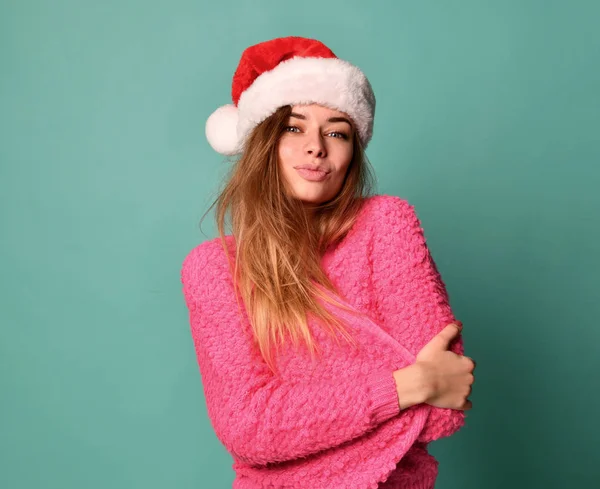 Bella modello femminile indossare Natale cappello di Babbo Natale felice sorridente baci in camicetta rosa sulla menta blu — Foto Stock