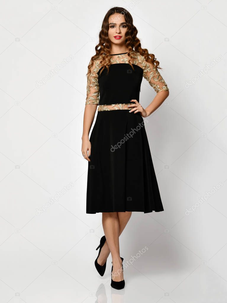 Young beautiful woman posing in new black fashion winter dress full body on a white 