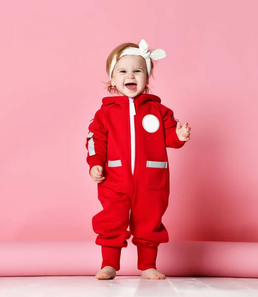 婴儿男婴幼儿在红体布使第一步站在快乐地看着浅粉色 — 图库照片