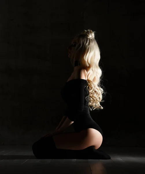 Νέος μόδα σέξι ξανθιά γυναίκα που κάθεται στο πάτωμα στο ύφασμα μαύρο σώμα και λαιμό — Φωτογραφία Αρχείου
