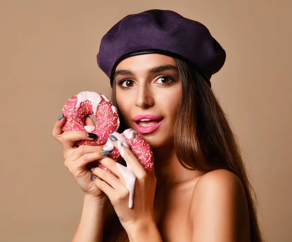 Woman hold Sweet pink sugar donuts hungry mouth on light brown background — Stock Photo, Image