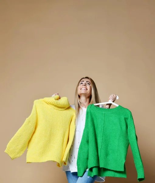 여자 쇼핑 크리스마스 판매 두 스웨터 블라우스 녹색과 노란색 행복 미소 사이 선택 — 스톡 사진