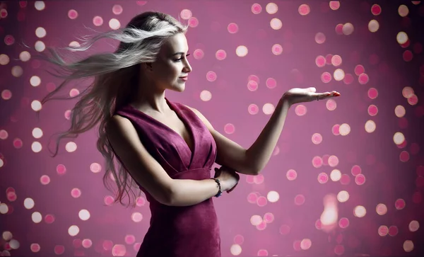 クリスマスお祝いライト パープル ピンクのテキスト領域を持つ手を指している金髪の女性美容師美容師 — ストック写真