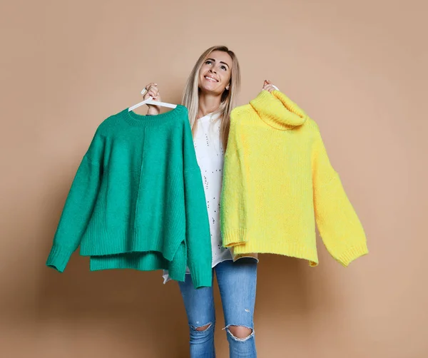Mujer de compras venta de Navidad elegir entre dos suéteres blusa verde y amarillo feliz sonrisa — Foto de Stock