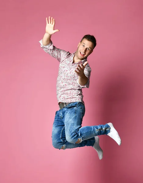 Feliz hombre ganador celebrando un acuerdo exitoso ganando señalando las manos con los dedos hacia arriba sobre rosa — Foto de Stock