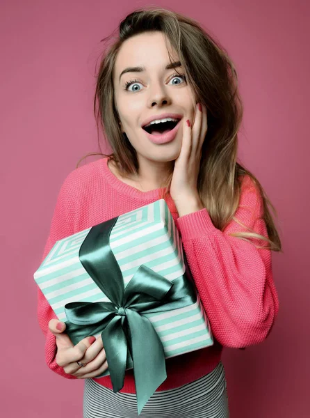 Красива молода жінка тримає пастельний зелений колір різдвяні подарунки подарункова коробка на Новий рік або день народження здивована — стокове фото