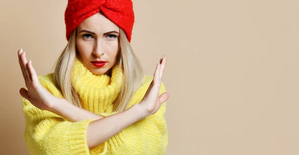 Жінка показує знак NO з хрестиком зупинити жест в жовтому светрі і червоній смузі голови з впевненим обличчям — стокове фото