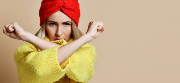 Mujer muestra NO signo con las manos cruzadas gesto de parada en suéter amarillo y banda de la cabeza roja con cara confiada —  Fotos de Stock