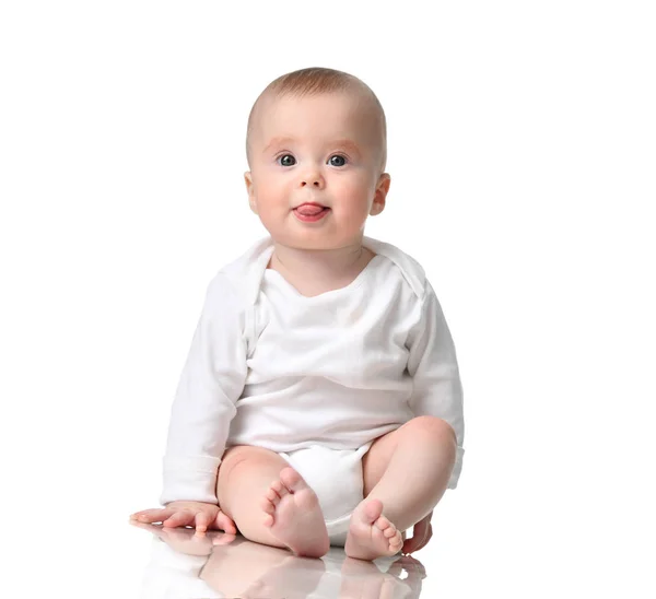 Bebé bebé niña niño sentado en la camisa del cuerpo muestran la lengua aislada en un blanco — Foto de Stock