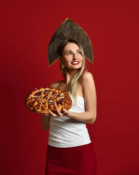 Donna in russo tradizionale cappello cappello kokoshnik felice sorridente tenere dolce ciliegia torta fatta in casa gustoso panino — Foto Stock