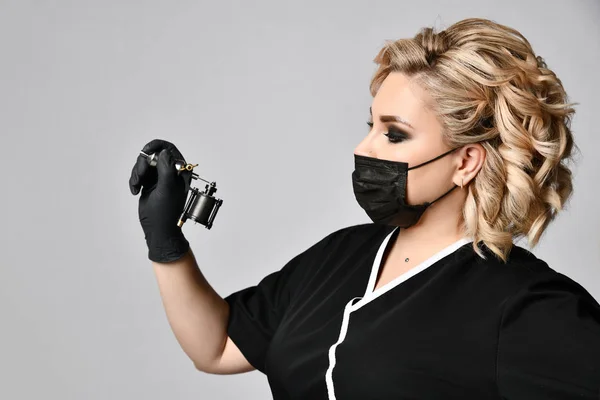 Γυναίκα αισθητικός cosmetologist λαβή δερματοστιξιών πολυβόλο στην μαύρη μάσκα σε γκρι — Φωτογραφία Αρχείου