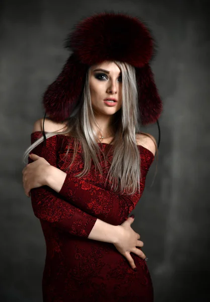 Portrait of young beautiful woman in new red fashion arctic fox winter fur ear flaps — Stock Photo, Image