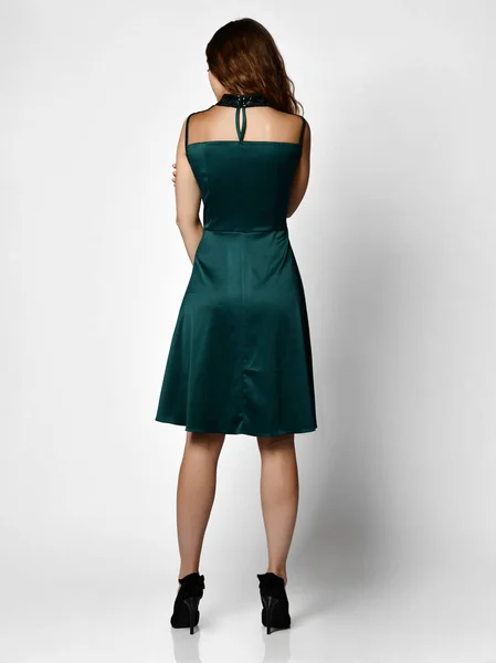 Young beautiful woman posing in new dark green fashion winter dress backside rear view — Stock Photo, Image